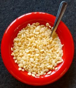 rice cereal in red bowl with silver spoon on black background arsenic in rice